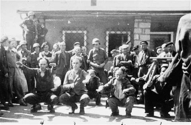 Survivors and American soldiers watch as former SS guards are forced to do calisthenics at the Gusen concentration camp